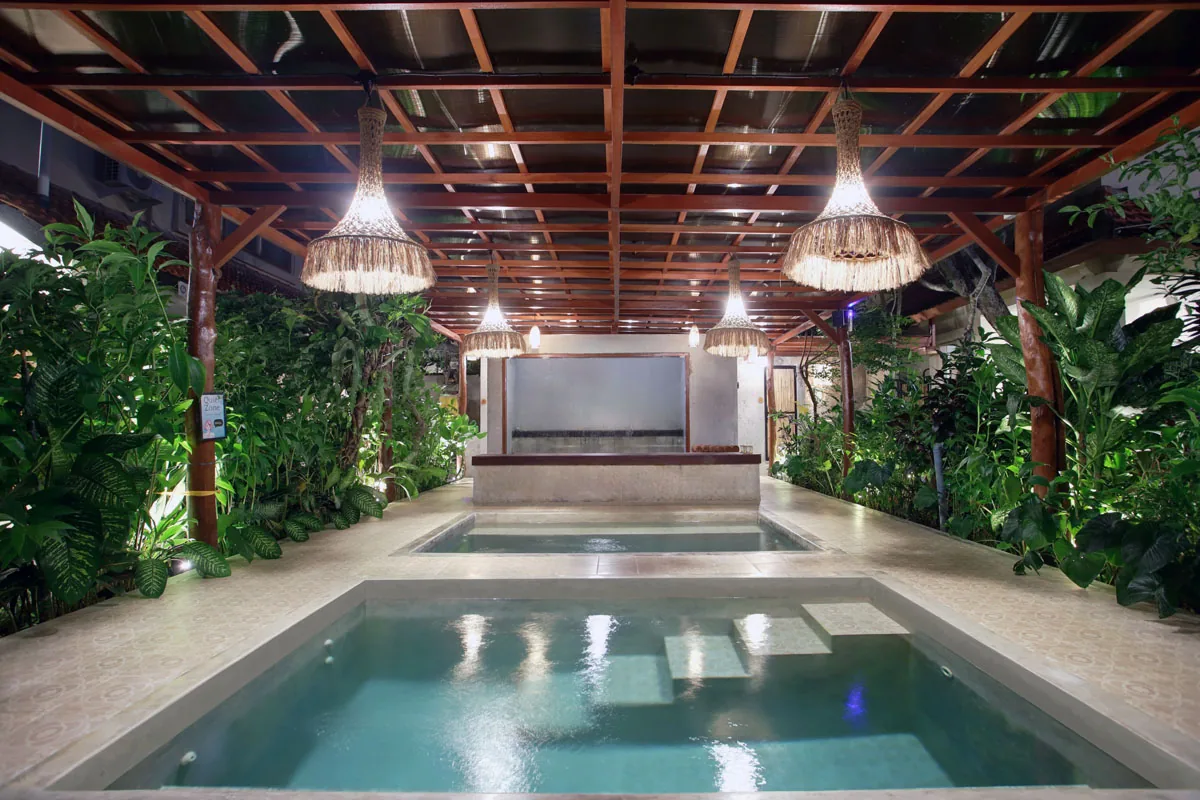 Hesa Downtown plunge pools illuminated at night with thatched pendant lights, Ubud Bali